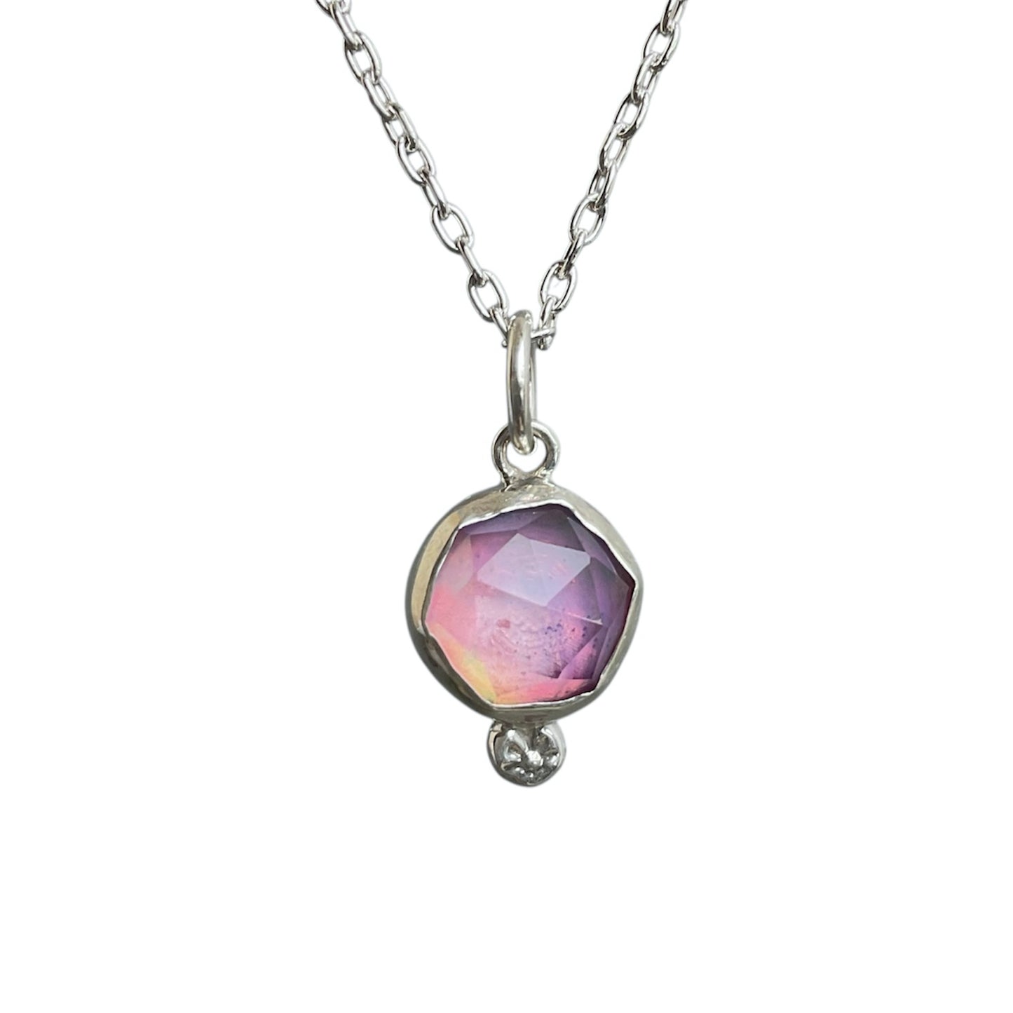 Necklace with a pendant featuring a pink gemstone on a white background