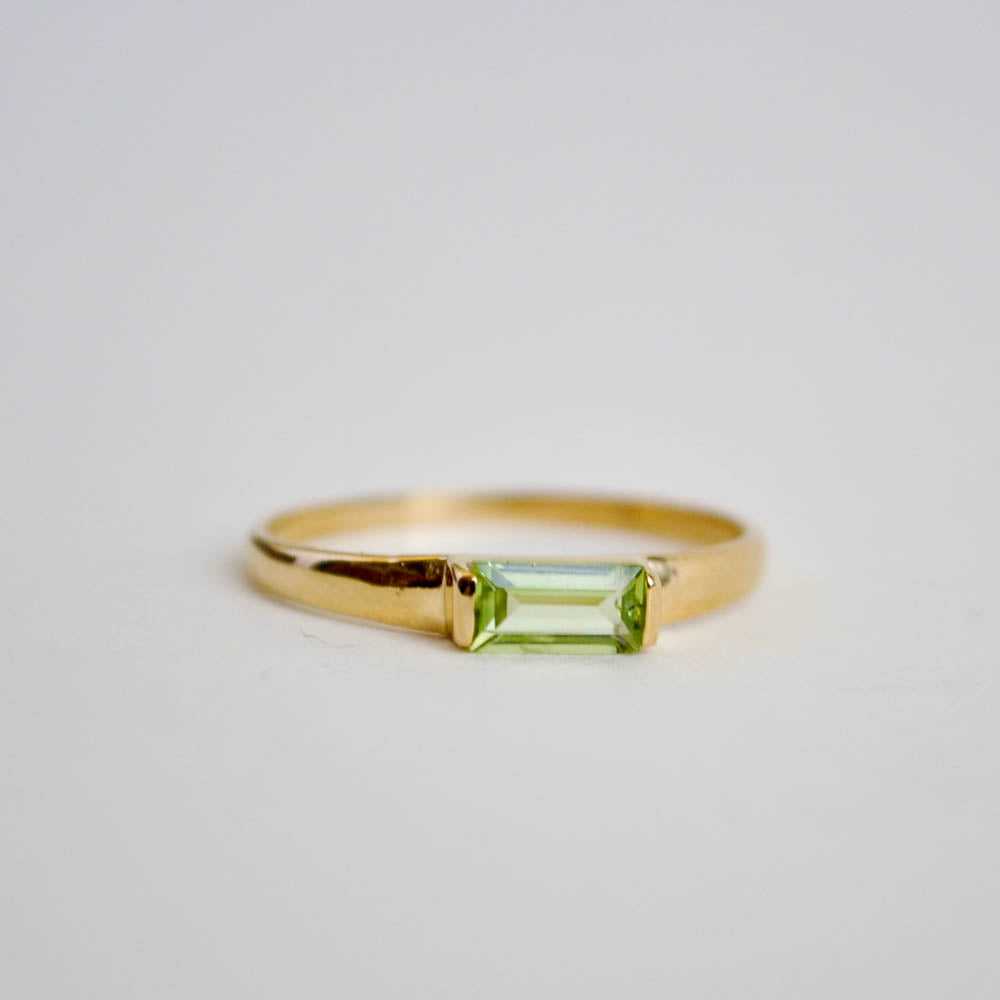 Green peridot baguete gemstone set horiztonally on a classic half round ring band in sterling silver and 14k gold vermeil