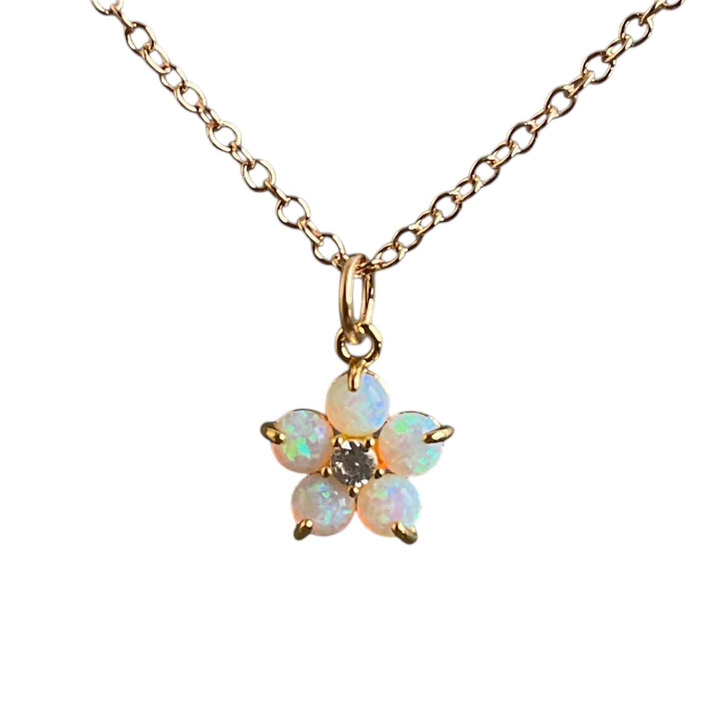 Flashy round opals make up the petals of a forget me not flower. Pendant on a gold chain.