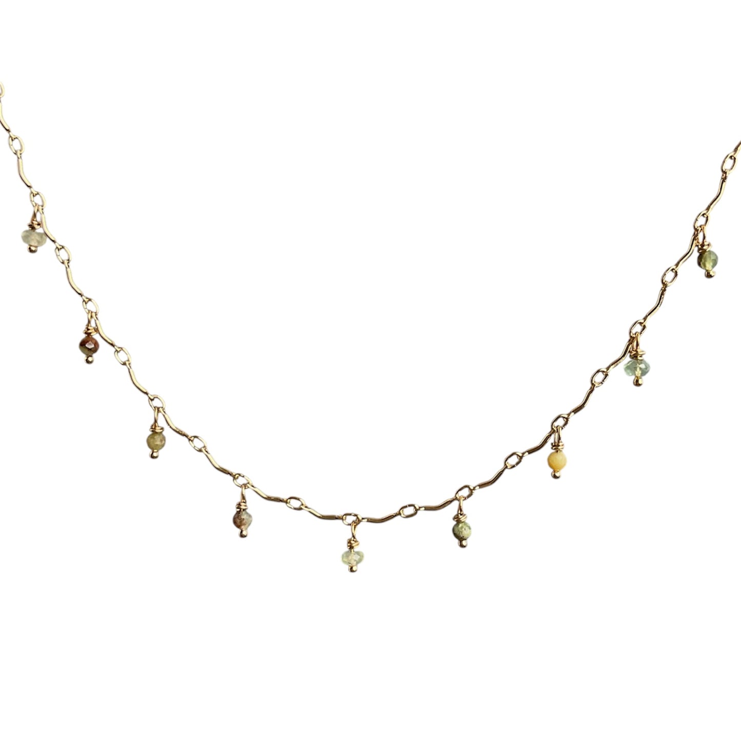 Delicate gold necklace with small beads on a white background