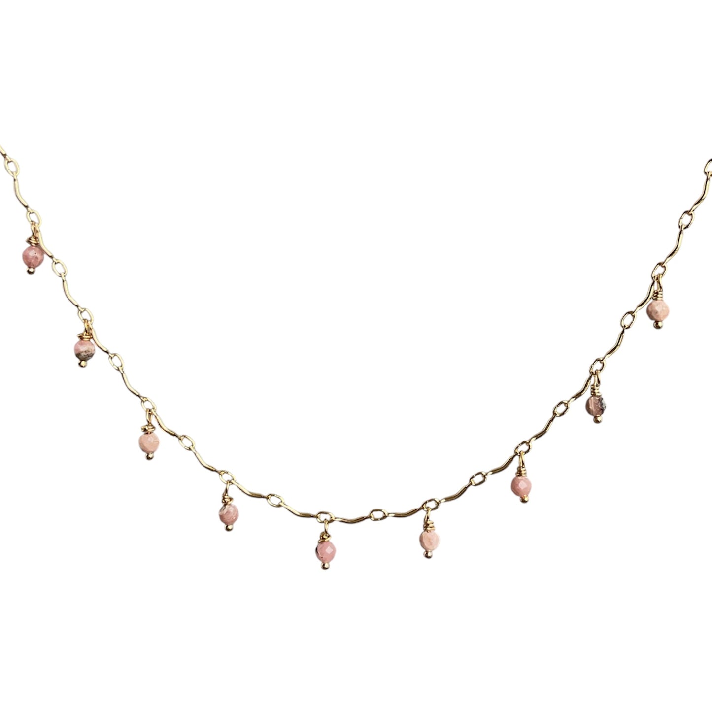 Gold scalloped necklace with pink beads on a white background