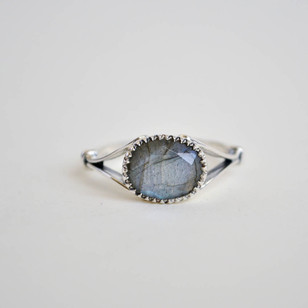 A flashy labradorite framed by a serrated bezel and a split ring band.