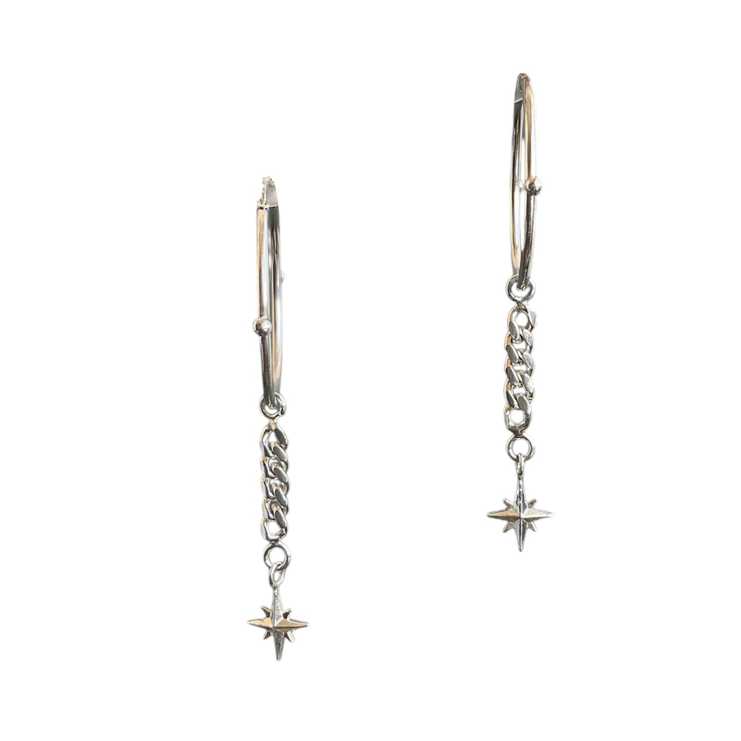 Hinged sterling silver hoops with a north star dangling at the end of a cuban link chain