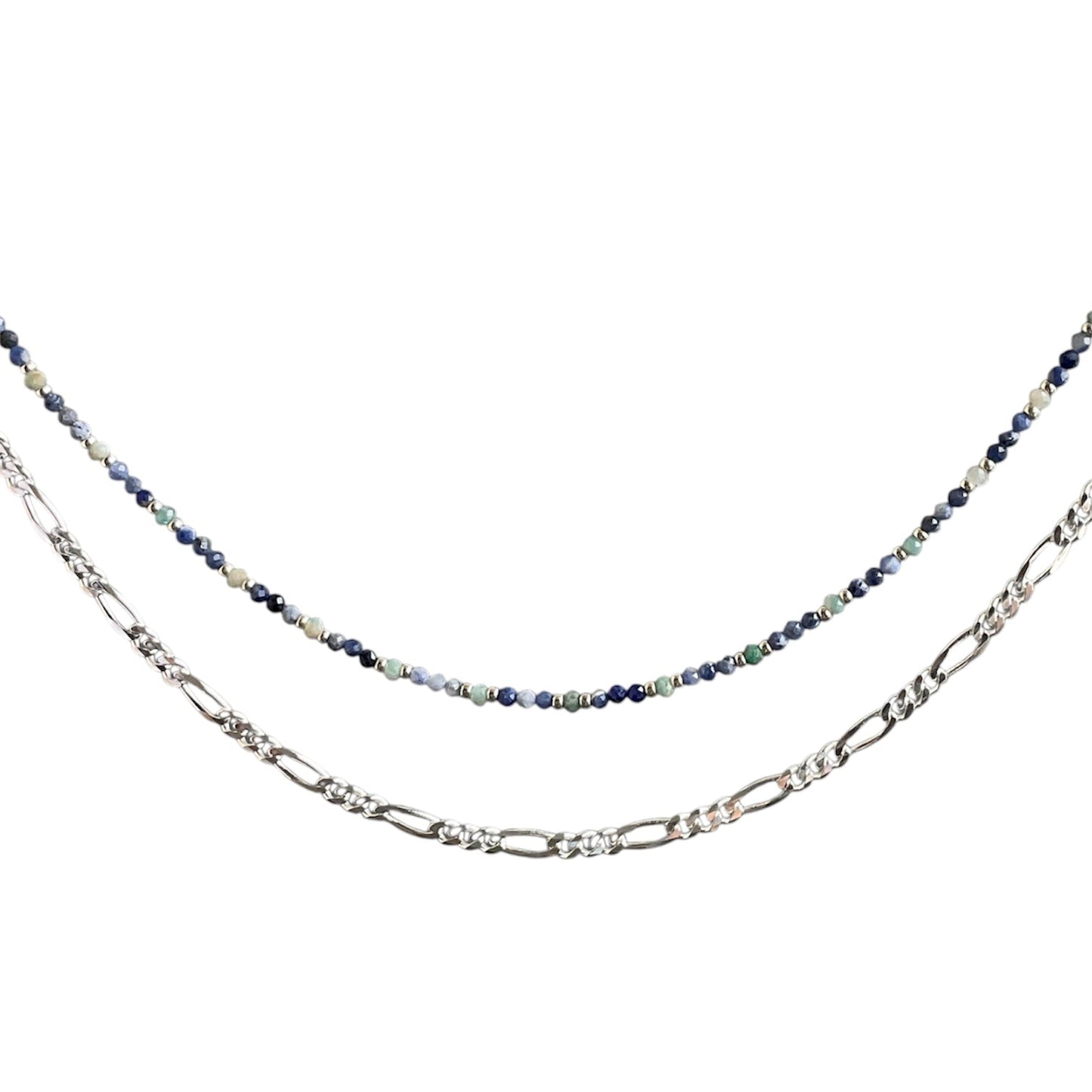 Layering necklace on a white background, one with a blue beaded chain and the other with a figaro chain.