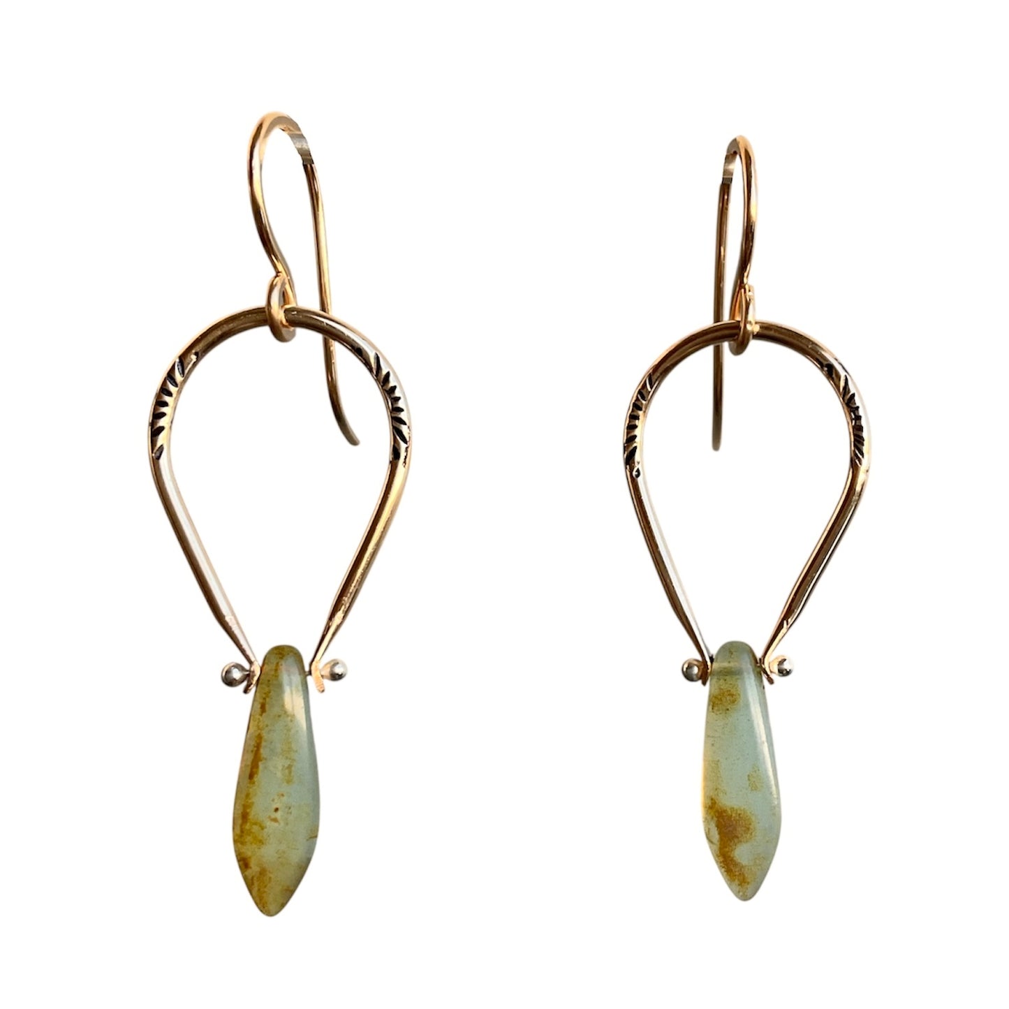 Pair of gold earrings with teardrop-shaped green stones on a white background