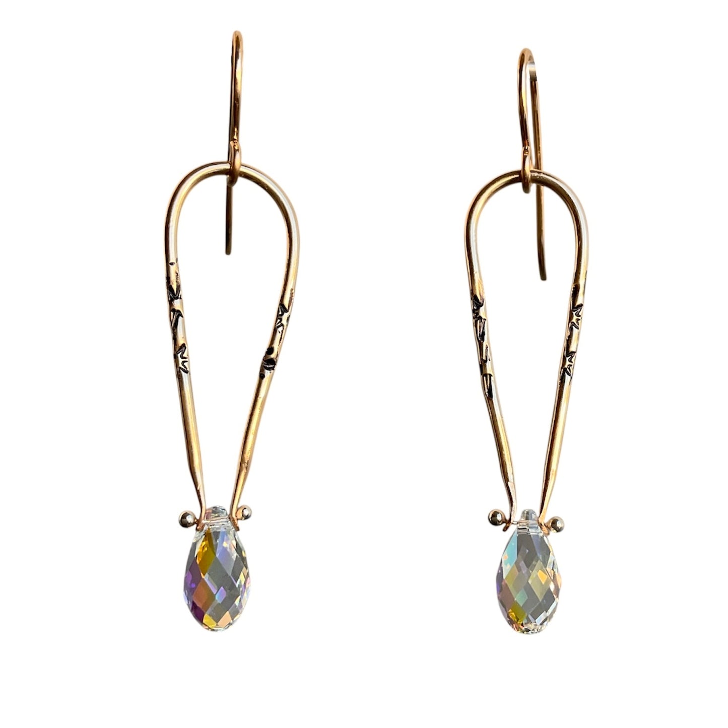 Gold earrings with iridescent teardrop-shaped gemstones on a white background