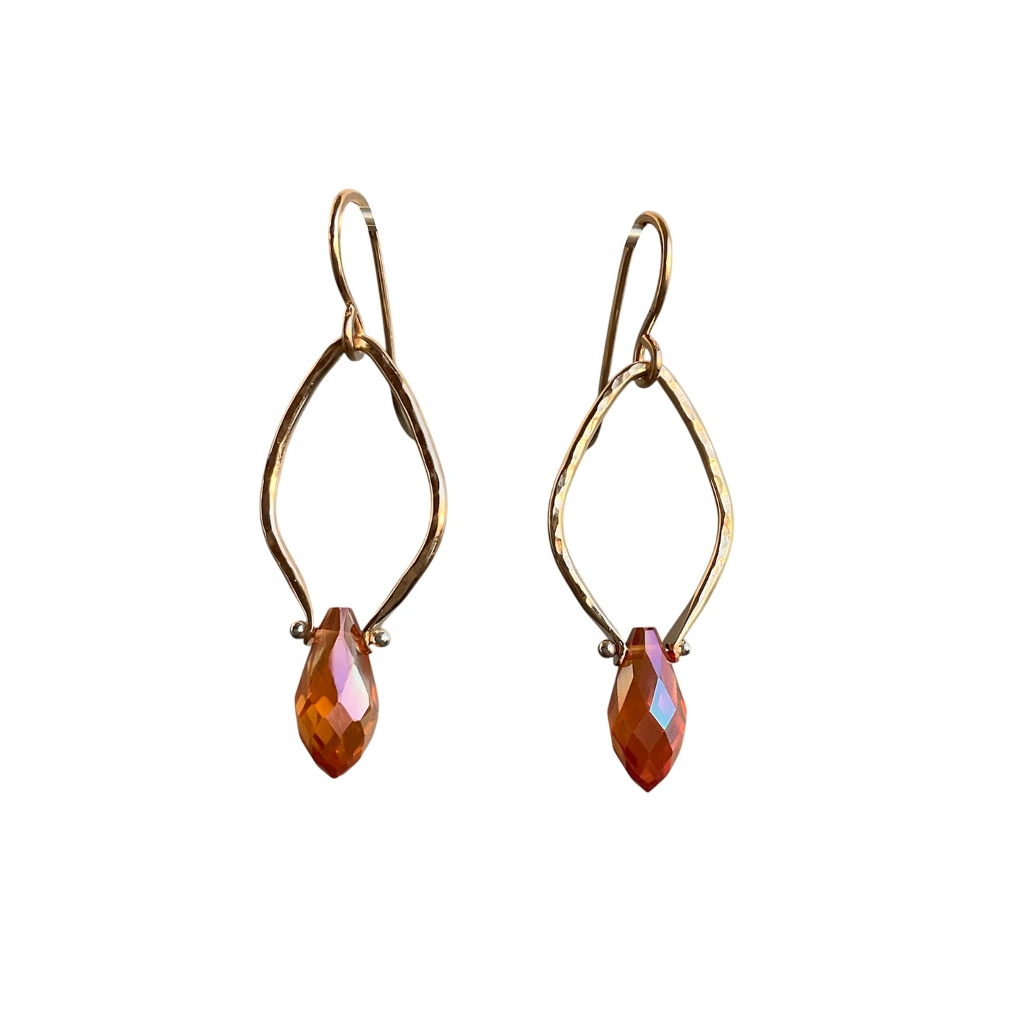 Gold earrings with marquise-shaped peach colored gemstones on a white background