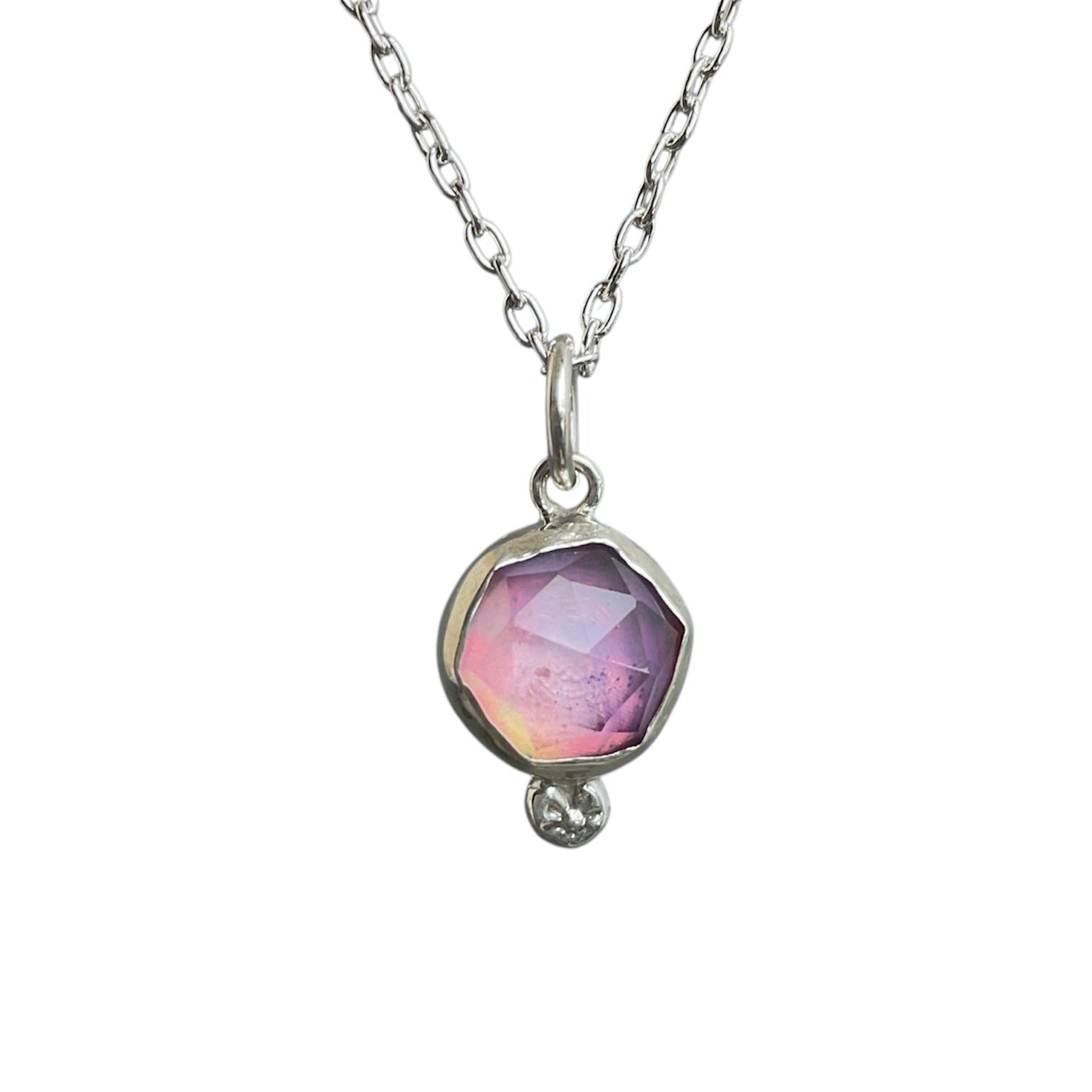 Necklace with a pendant featuring a pink gemstone on a white background