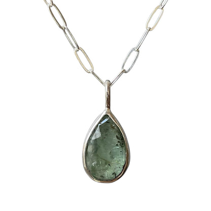 Teardrop-shaped pendant necklace with a silver chain on a white background