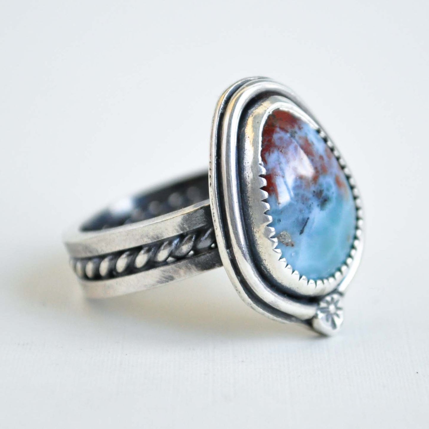 Silver ring with a large blue stone on a white background