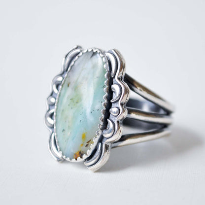 Silver ring with a large turquoise stone on a light gray background