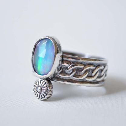 Silver ring with a colorful gemstone on a white background