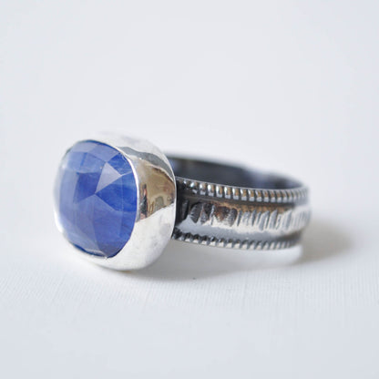 Silver ring with a blue stone on a white background
