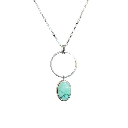 Circle element with a mint green oval varascite gemstone hanging. All on a sterling silver chain.