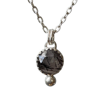 Necklace with a dark gemstone pendant on a white background