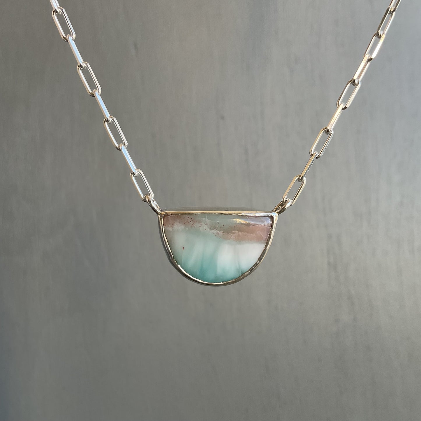 Necklace with a semi-circular pendant on a gray background