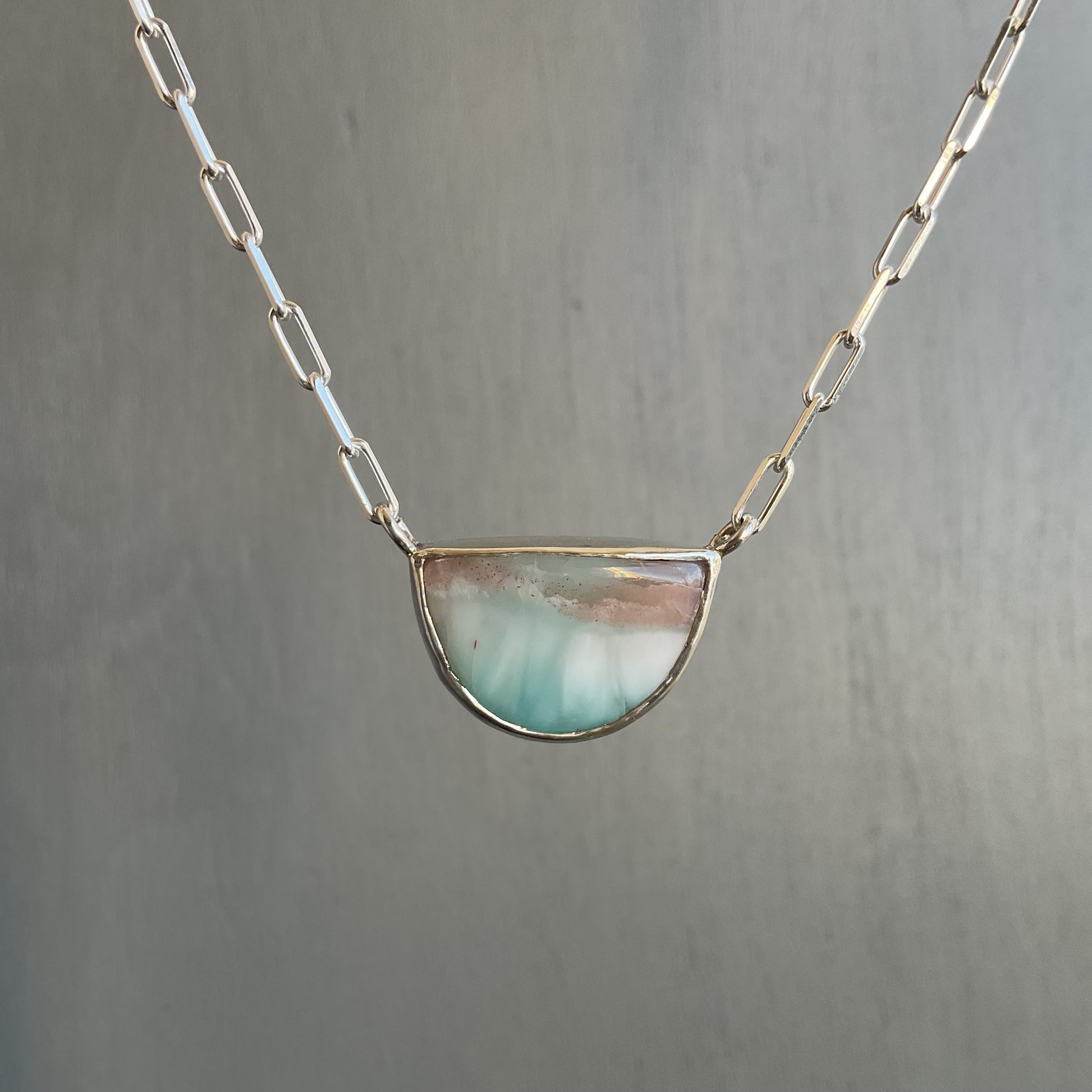 Necklace with a semi-circular pendant on a gray background