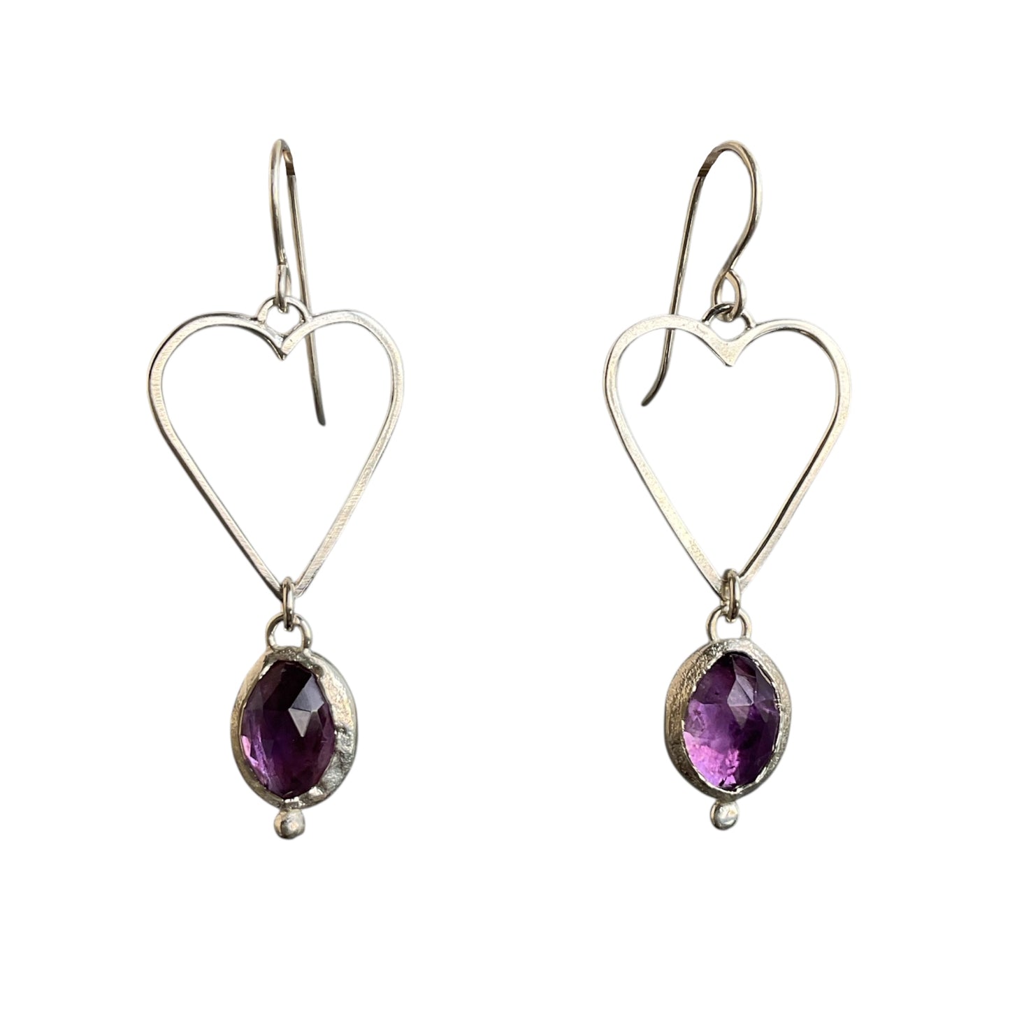 Heart-shaped silver earrings with purple gemstones on a white background