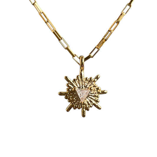Gold necklace with a sun-shaped pendant on a white background