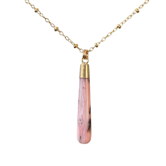 Necklace with a pink teardrop pendant on a gold chain against a white background