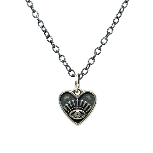 A necklace with an oxidized sterling silver chain and a heart-shaped pendant with an eye design in the center.