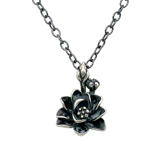 A sterling silver necklace with a oxidized finish featuring a lotus flower pendant.