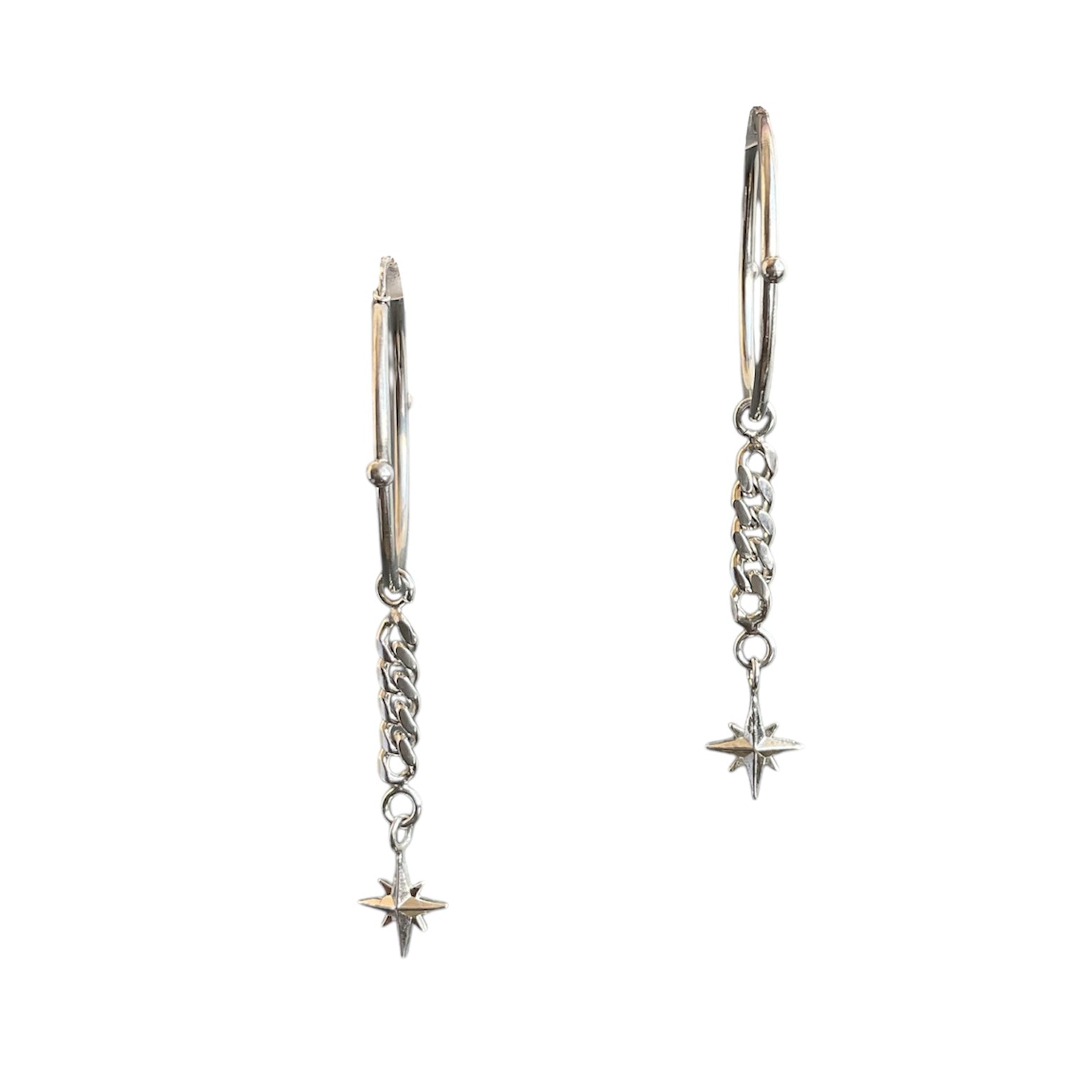 Hinged sterling silver hoops with a north star dangling at the end of a cuban link chain