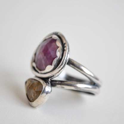 Silver ring with a purple gemstone on a white background